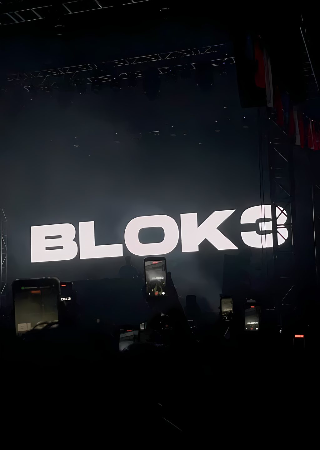 Sahne ışıklarının kestiği karanlık bir rap konseri atmosferi, siluetler ve ışık huzmeleri